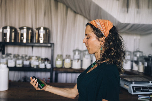 A Woman with Orange Headscarf Holding Green Bottle