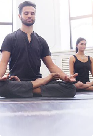 An image of a man and woman meditating on yoga mats representing the calming effect of Soothe Organic's CBD softgels.