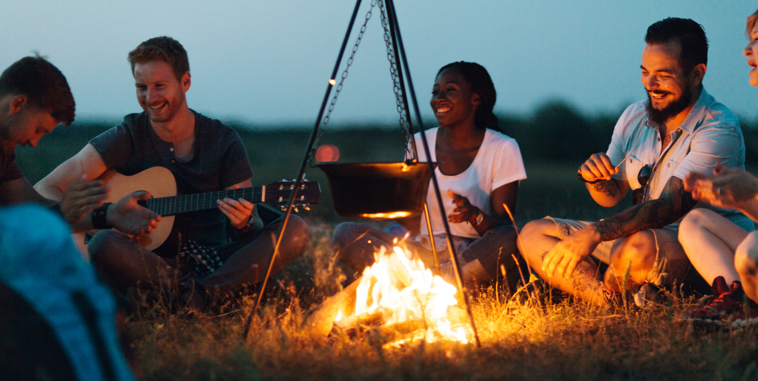 A group of friends sitting around a warm and cozy campfire, enjoying each other's company