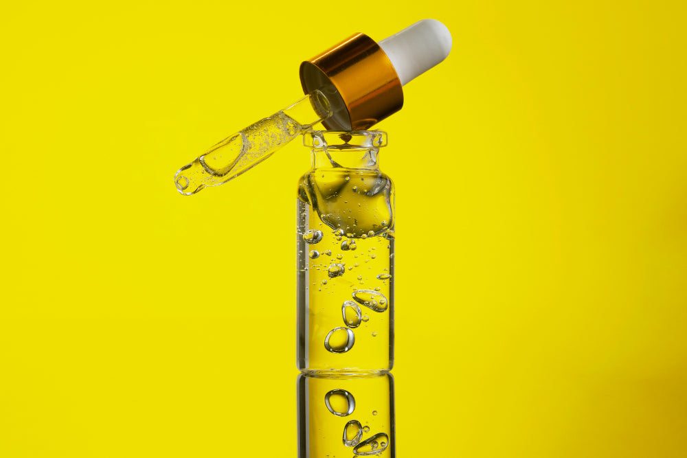 Close-up of a dropper releasing clear water-soluble CBD liquid under a person’s tongue, with soft natural light and a calm wood background.