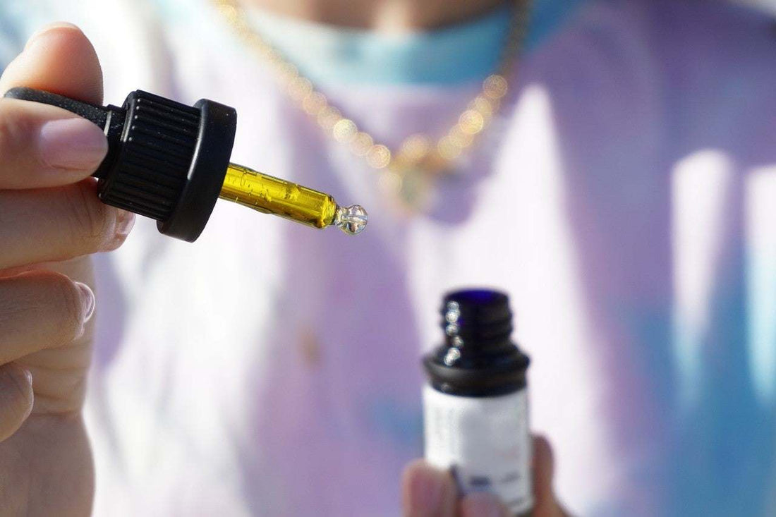 Flat lay of USDA Organic CBD products on a wooden table — tincture, gummies, softgels, and topical balm with a Certificate of Analysis card visible.