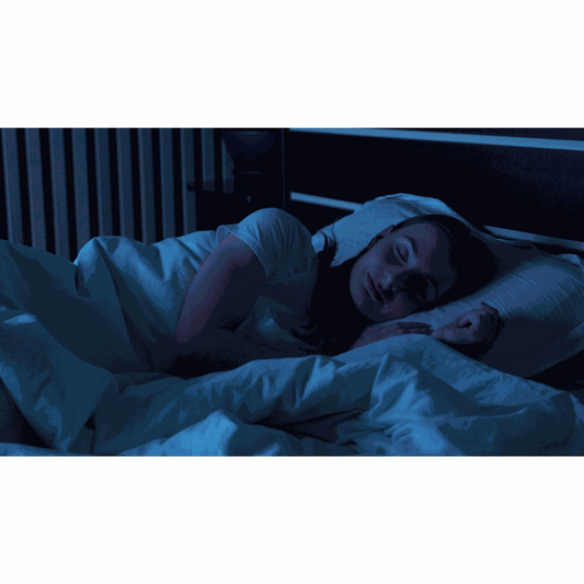 A Soothe Organic sleep tincture and CBD CBN melatonin gummy bottle on a quiet bedside table at dusk beside a closed book