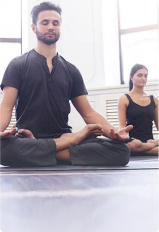 A man and a woman practicing yoga, performing various poses and stretches to improve their strength, flexibility, and overall well-being