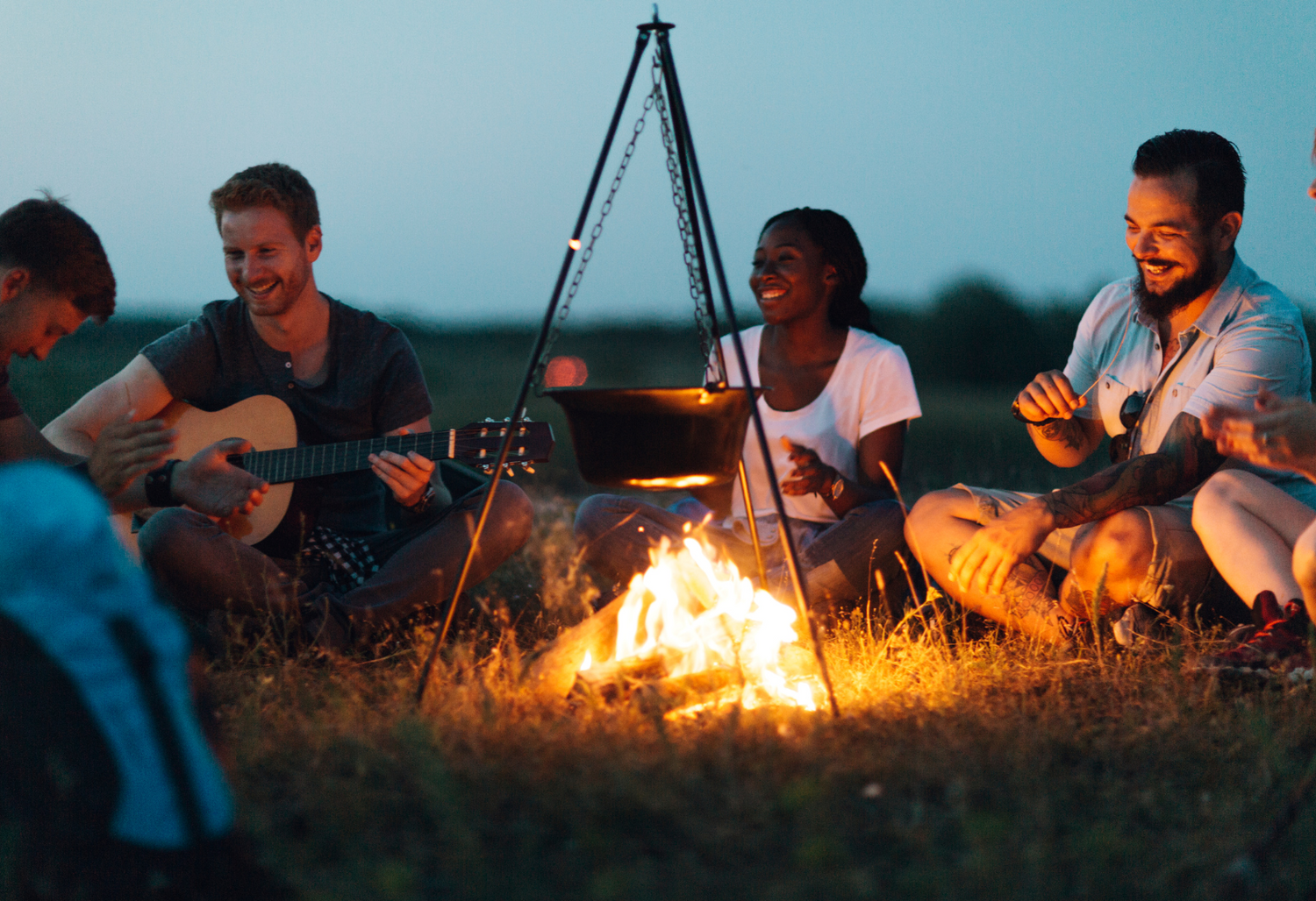 A group of friends sitting around a warm and cozy campfire, enjoying each other's company